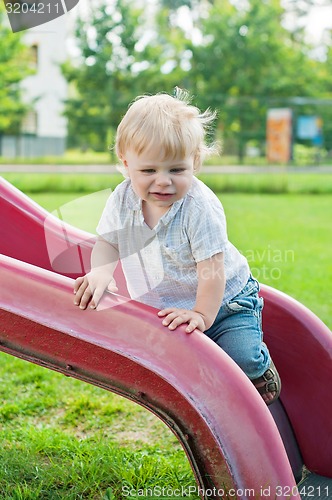 Image of Baby kid standing on red slide