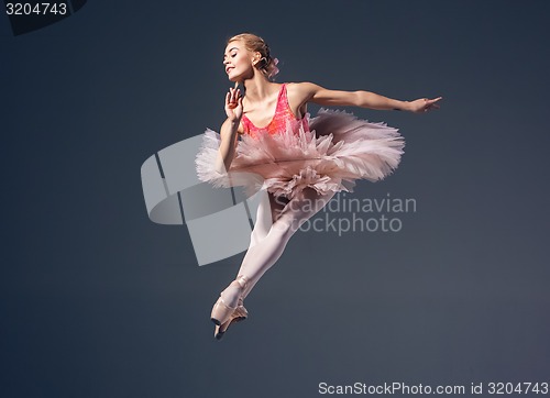 Image of Beautiful female ballet dancer on a grey background. Ballerina is wearing  pink tutu and pointe shoes.