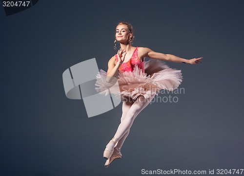 Image of Beautiful female ballet dancer on a grey background. Ballerina is wearing  pink tutu and pointe shoes.