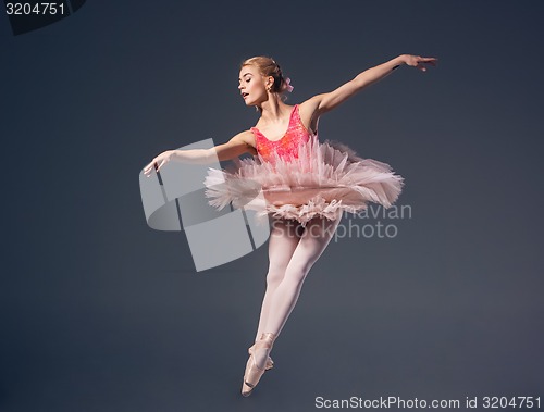 Image of Beautiful female ballet dancer on a grey background. Ballerina is wearing  pink tutu and pointe shoes.