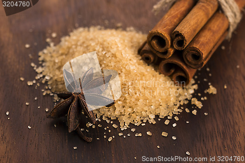 Image of Cinnamon sticks with pure cane brown sugar on wood background