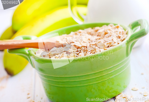 Image of Oat flakes in the green bowl with banana and milk