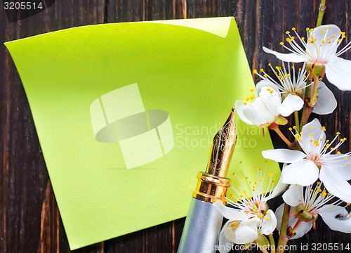 Image of flowers and paper on wooden background