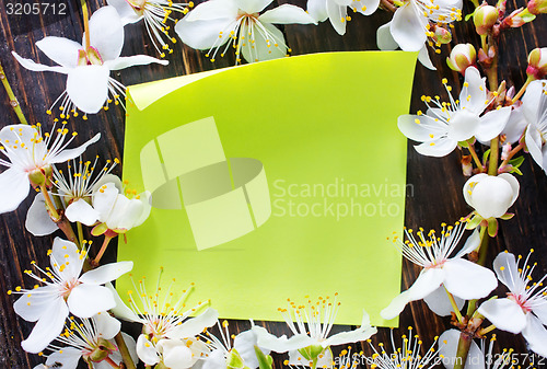 Image of flowers and paper on wooden background