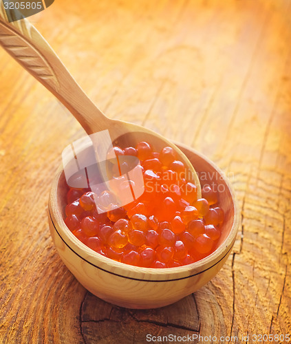 Image of Red salmon caviar in the wooden bowl and spoon