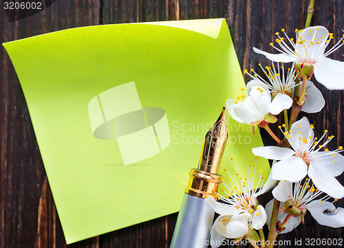 Image of flowers and paper on wooden background