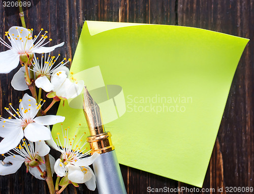 Image of flowers and paper on wooden background