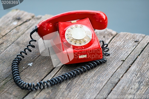 Image of Red phone on wooden deck