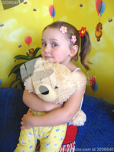 Image of girl playing with her bear toy in her room