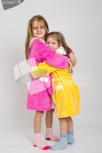 Image of Two sisters hug after a bath