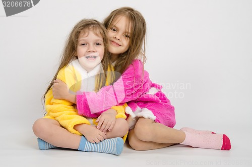 Image of Two girls sit in robes