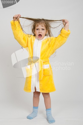 Image of Girl in a yellow robe lifted wet hair