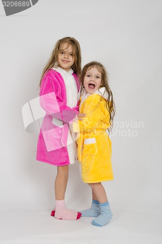 Image of Two girls in gowns hugging each other