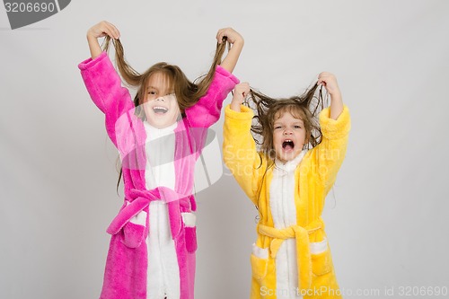 Image of Two girls in the bath robes grimace hair