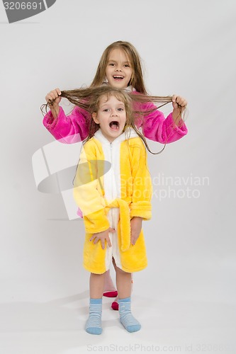 Image of Girl holding her sisters wet hair
