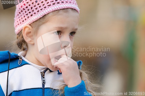 Image of Girl in thought stuck a finger her mouth