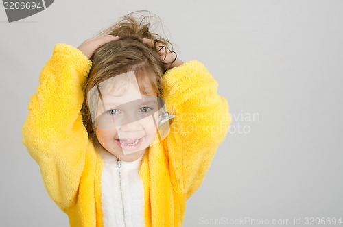 Image of Joyful girl in a yellow bathrobe