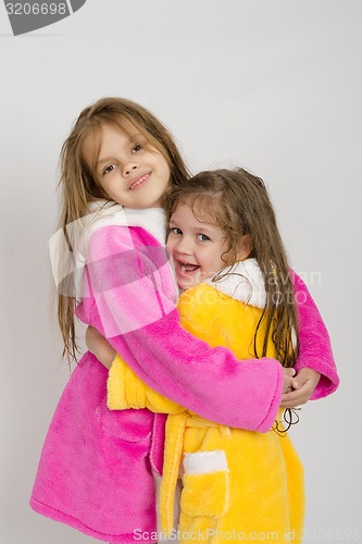Image of Girls in pink and yellow robe hug