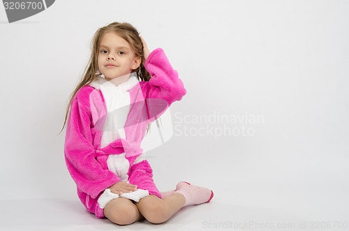 Image of Six year old girl in a bathrobe straightens hair