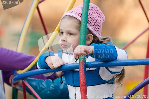 Image of Four-year girl thought playing on the playground