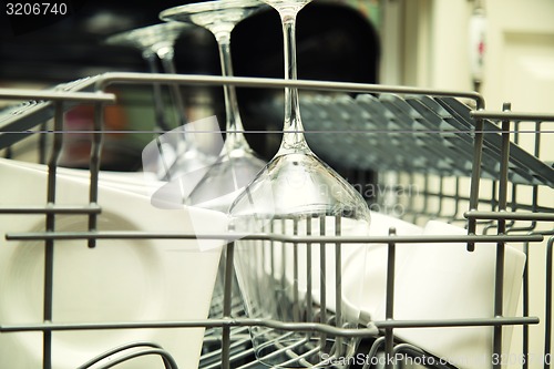 Image of details of Open dishwasher with clean utensils