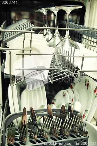 Image of details of Open dishwasher with clean utensils