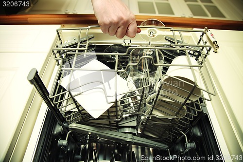 Image of Kitchen Woman with a clean wine glass on background dishwasher
