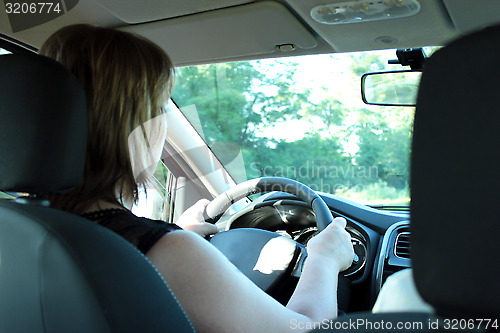 Image of Young woman driving the car