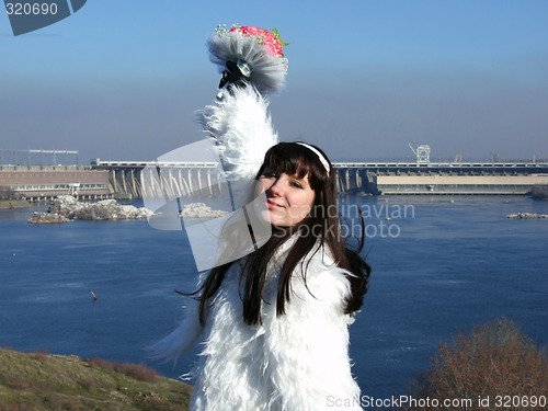 Image of The young bride in a white dress with a bouquet of flowers