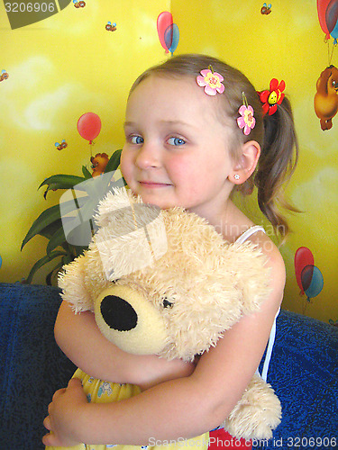 Image of girl playing with her bear toy in her room