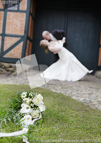 Image of Bridal bouquet before wedding couple kissing