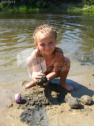 Image of little girl is playing at the river