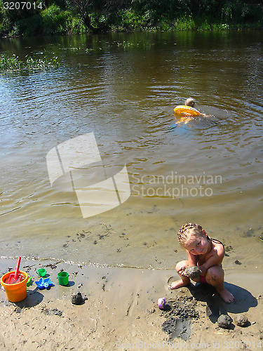 Image of little girls playing on the sand at the river