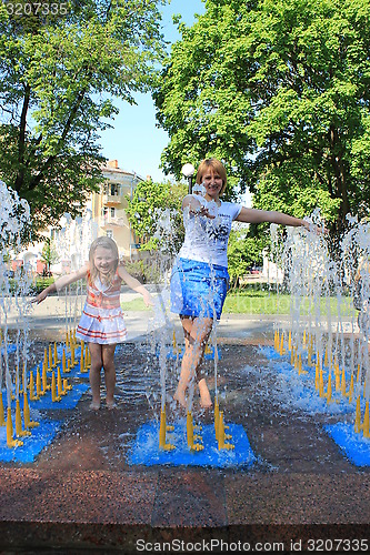 Image of mother and daughter playing in fountains