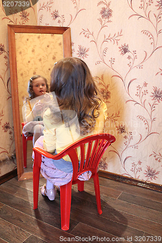 Image of girl makes up her face before a mirror