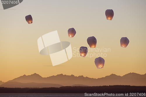 Image of Sky lanterns flying upwards\r