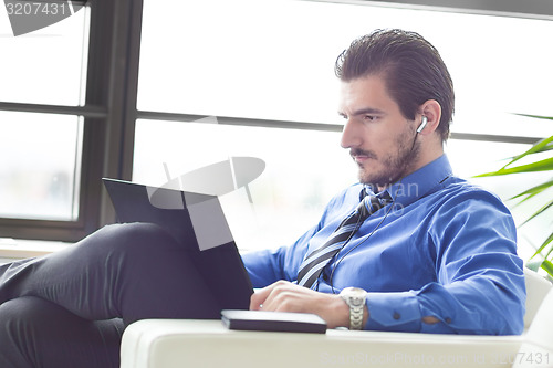 Image of Businessman in office working on his laptop. 