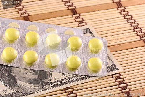 Image of Pills and american money close-up background