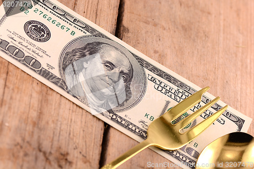 Image of american money on wooden plate with knife and fok