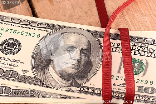 Image of Bundle of dollars tied with ribbon