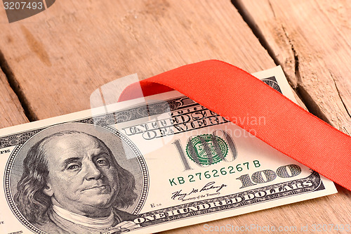 Image of One Hundred Dollar Bills Wrapper in Red Ribbon