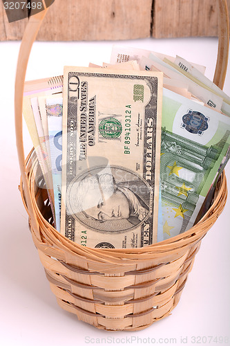 Image of money set in a basket, dollars, euro and ukrainian money