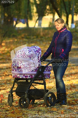 Image of woman with baby in perambulator in the park