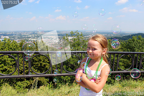 Image of little girl with soap bubbles out of city