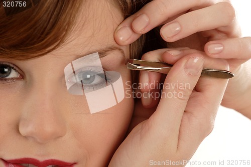 Image of Woman  plucking eyebrow