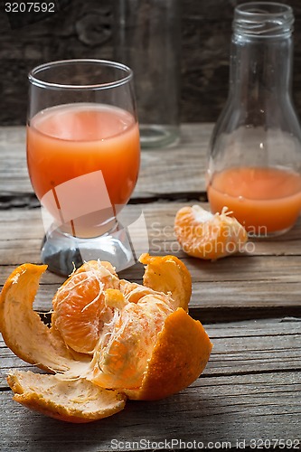 Image of fresh juice of tropical citrus fruits on wooden background