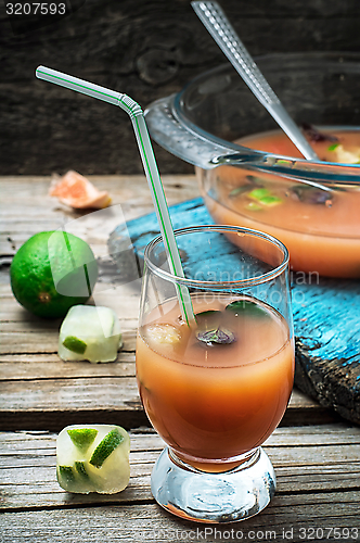 Image of fresh juice of tropical citrus fruits on wooden background