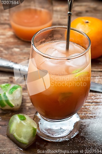 Image of fresh juice of tropical citrus fruits on wooden background