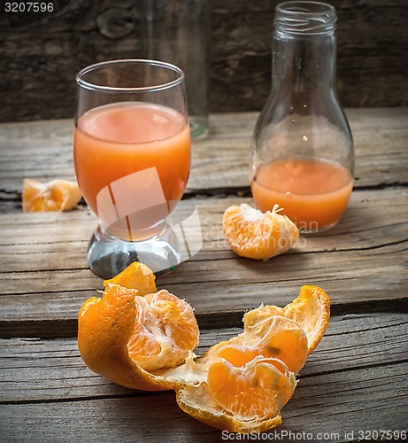 Image of fresh juice of tropical citrus fruits on wooden background