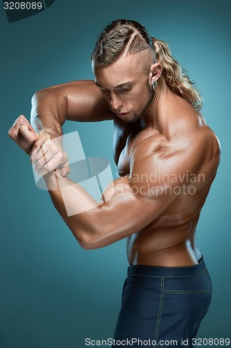 Image of Attractive male body builder on blue background